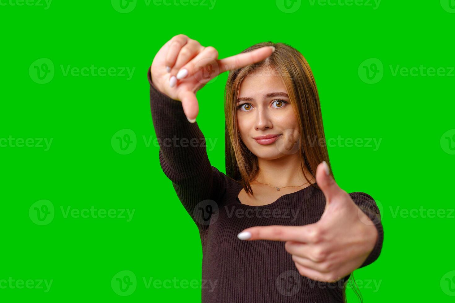 Woman Framing With Fingers On Green Screen photo