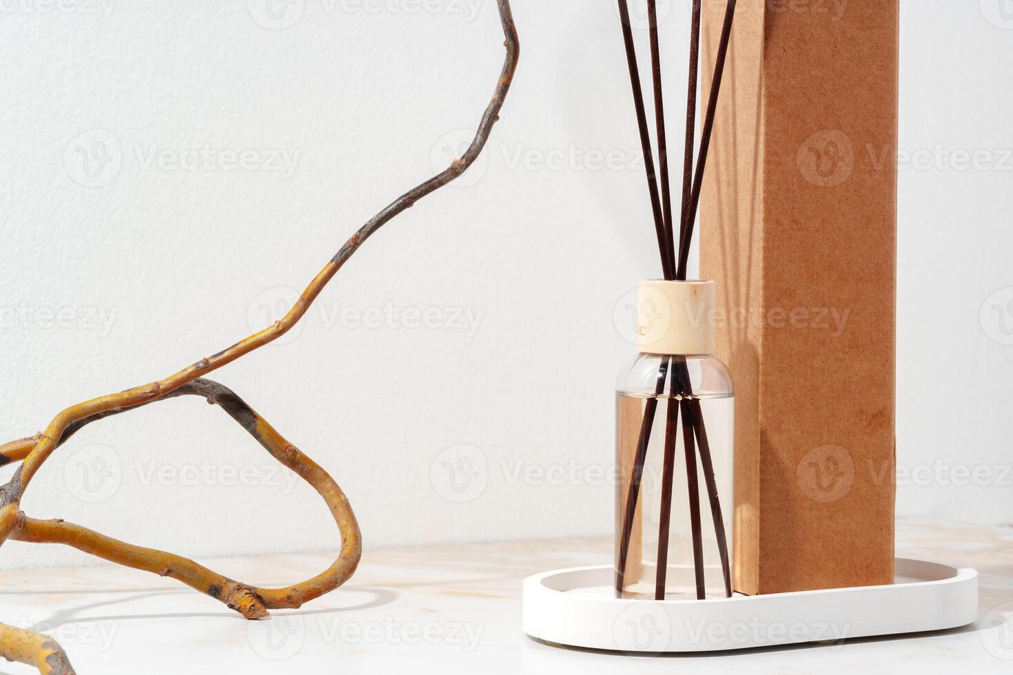 Reed Diffuser Bottle With Wooden Sticks on White Tabletop photo