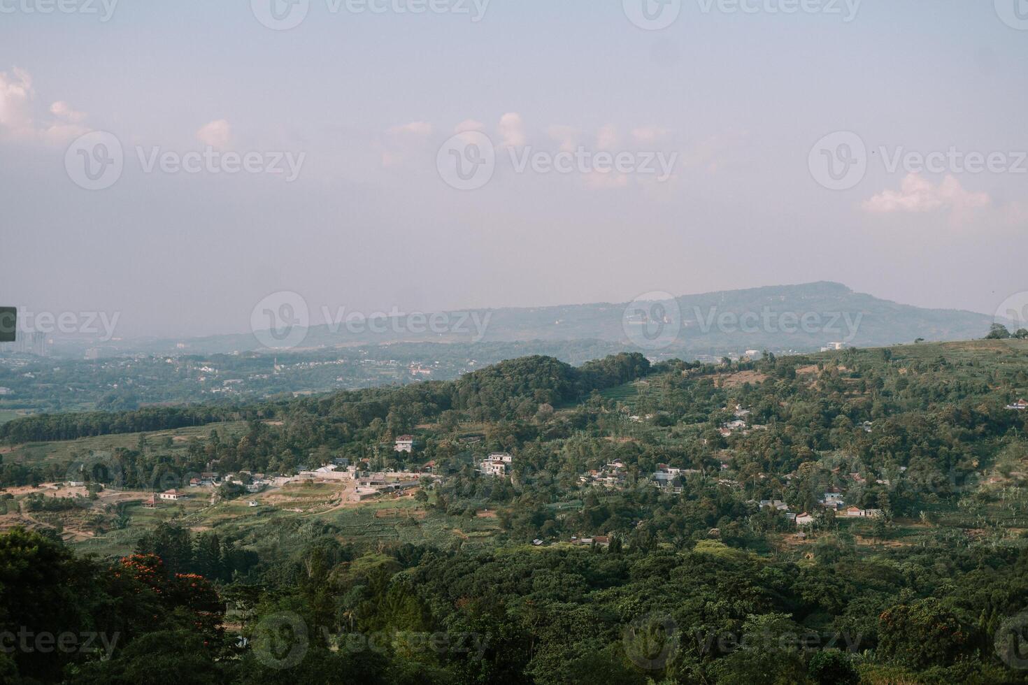 Scenic view of lush green hills in a serene village, showcasing rolling landscapes and vibrant foliage photo