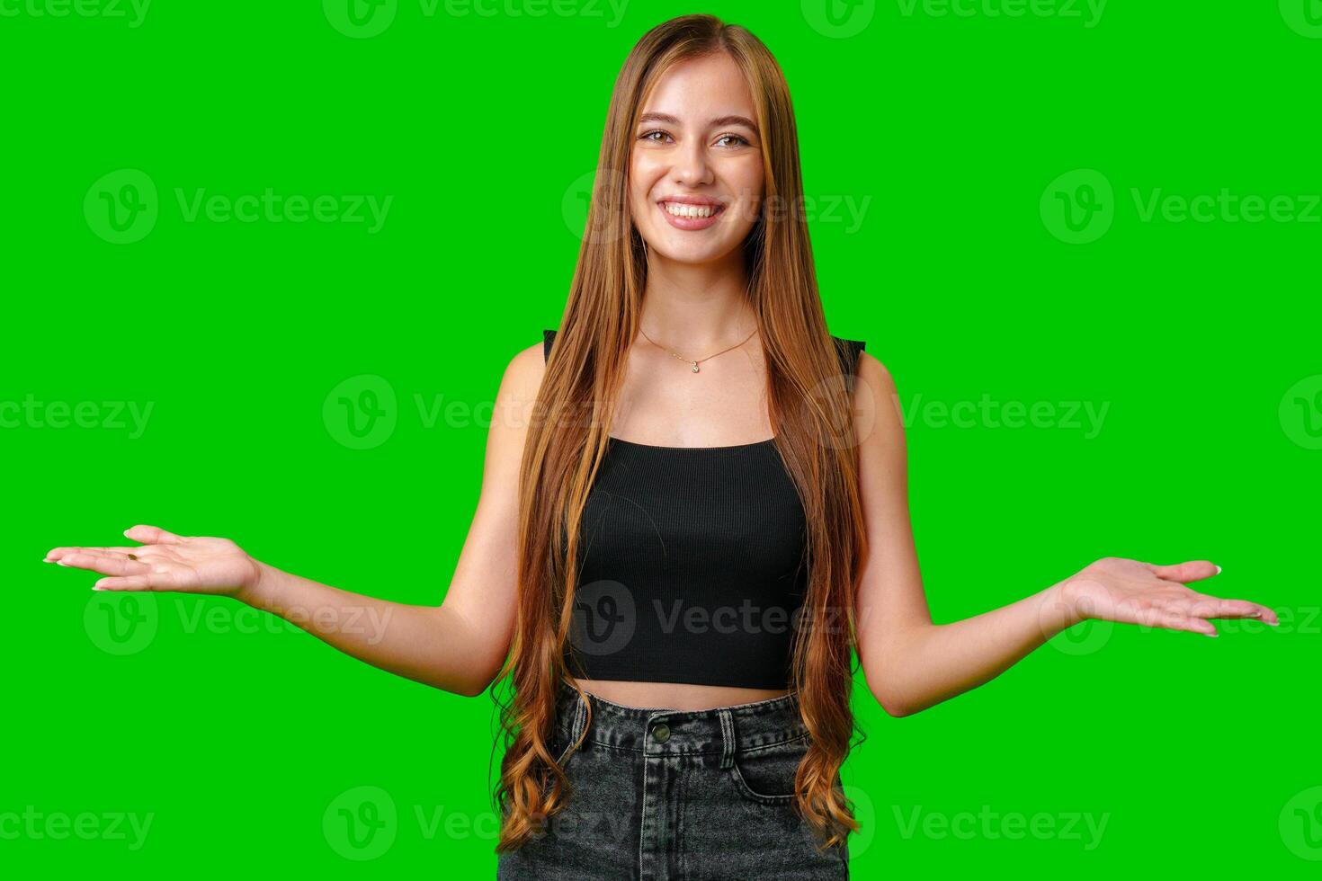 Smiling Young Woman With Open Palms Gesturing On Green Screen photo