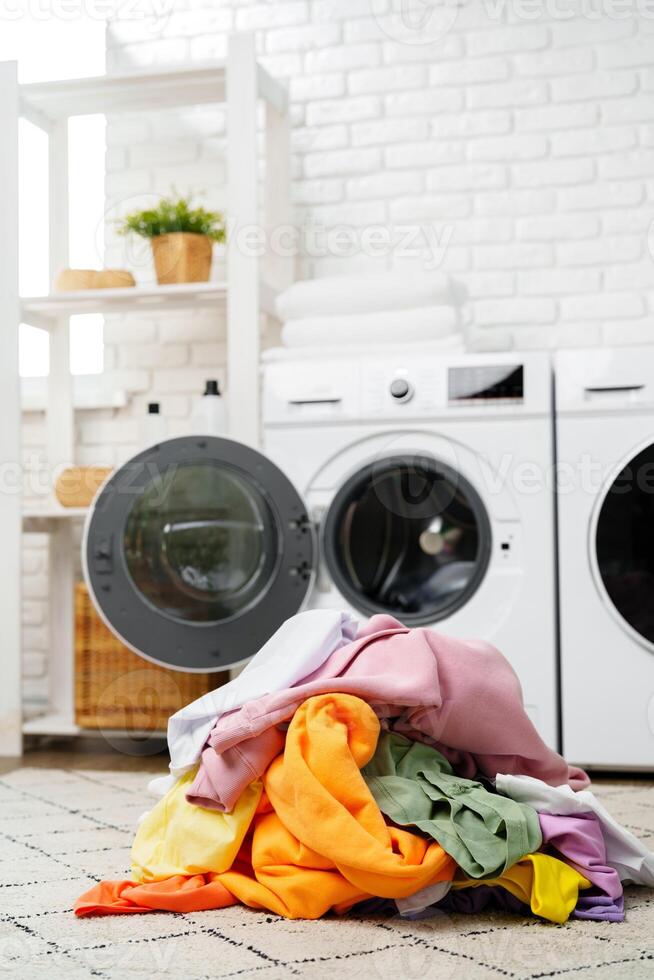 A Pile of Clean Laundry Beside a White Washing Machine in a Modern Home photo