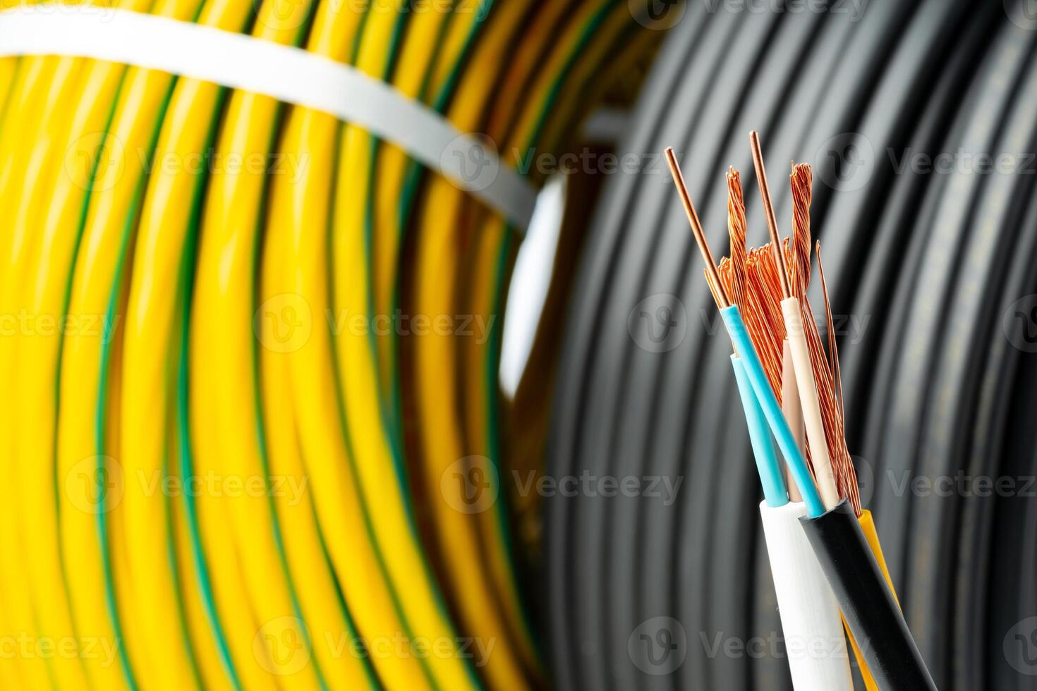 Closeup of Stripped Electrical Wires Against Rolled Cable photo