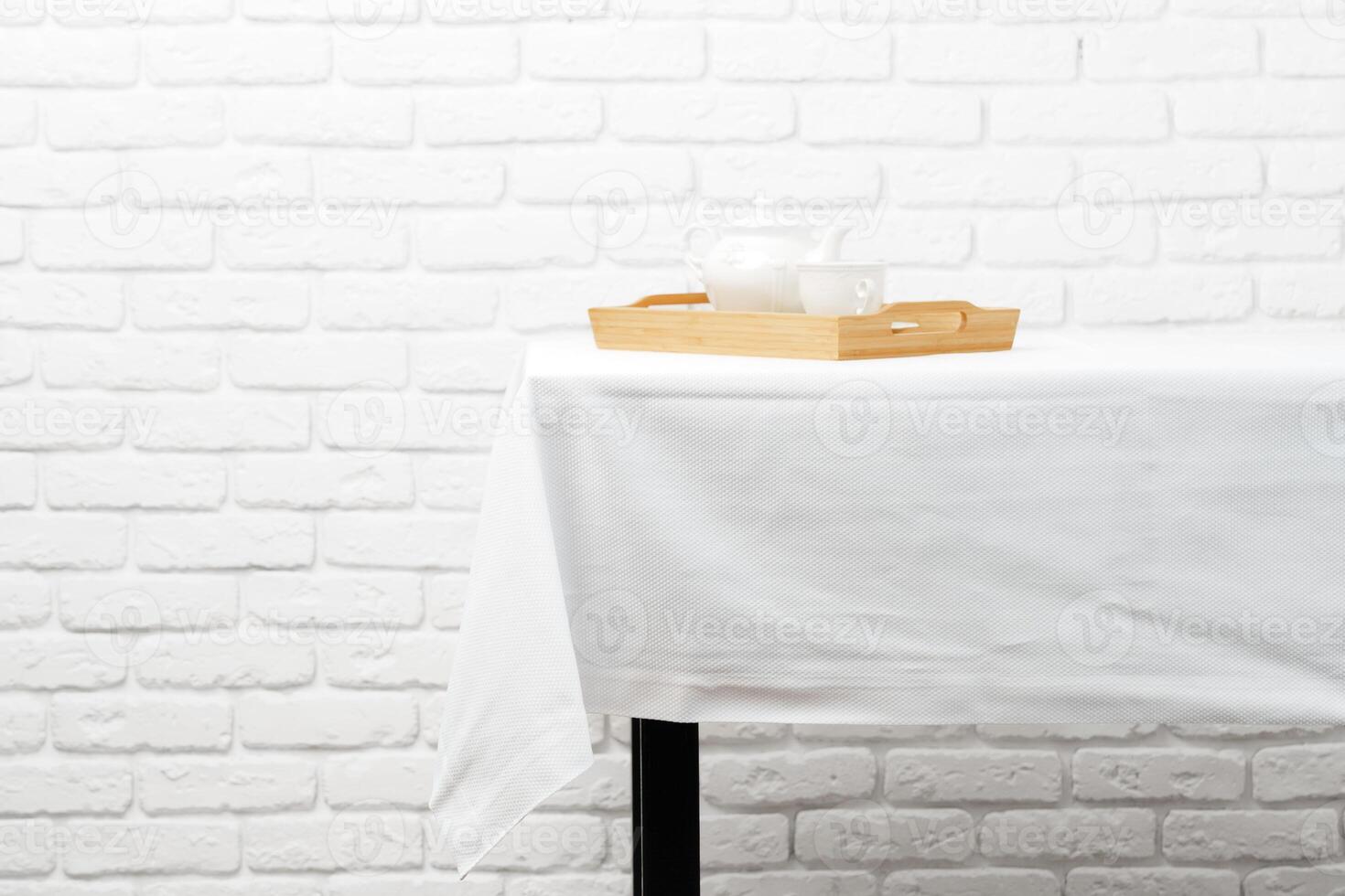 White Textured Tablecloth Draped Over Black Table Leg photo