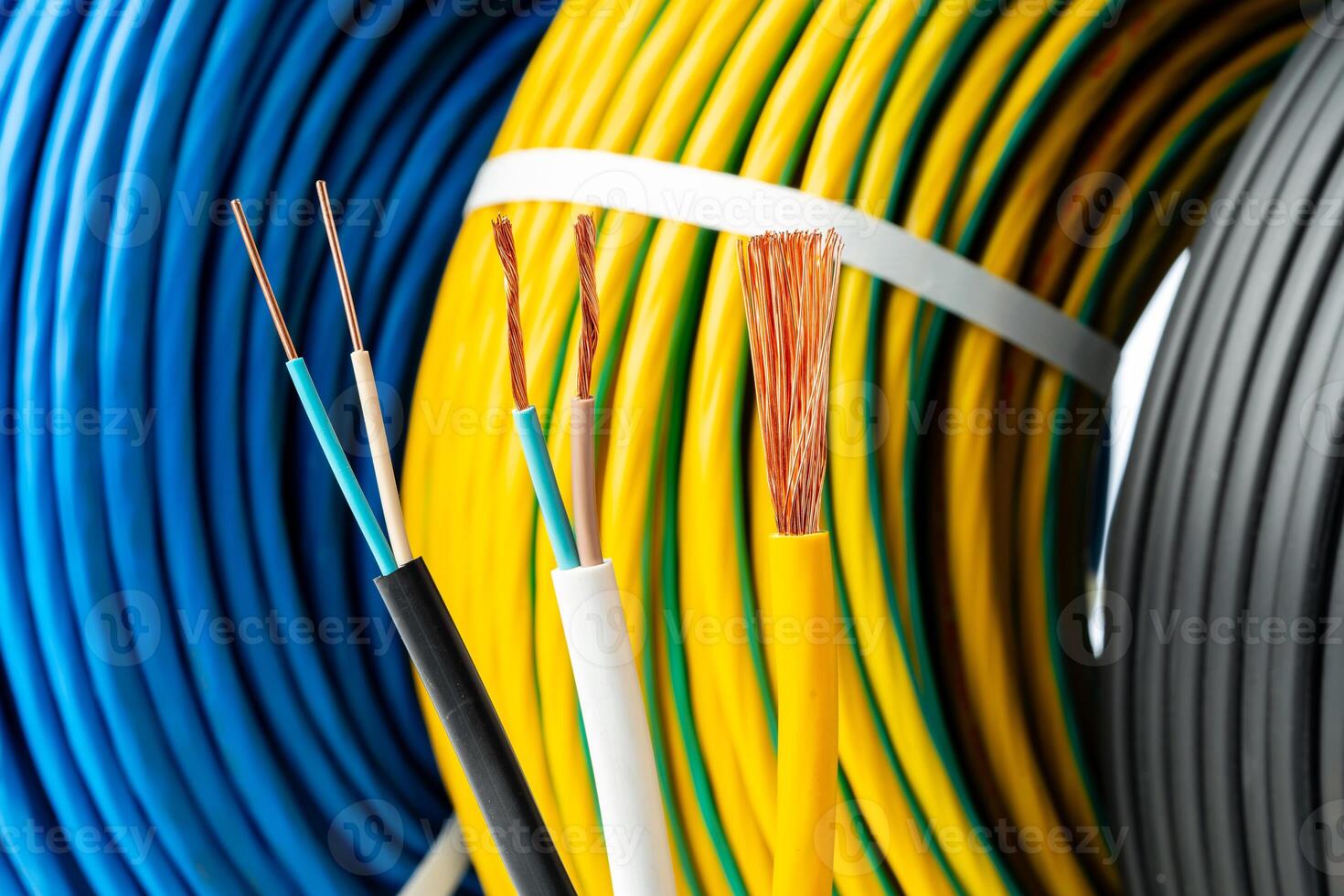 Closeup of Stripped Electrical Wires Against Rolled Cable photo