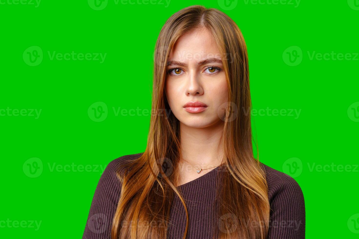 Young Woman With Serious Expression Against Green Screen photo