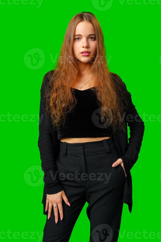 Young Woman With Long Hair Standing in Front of Green Screen photo