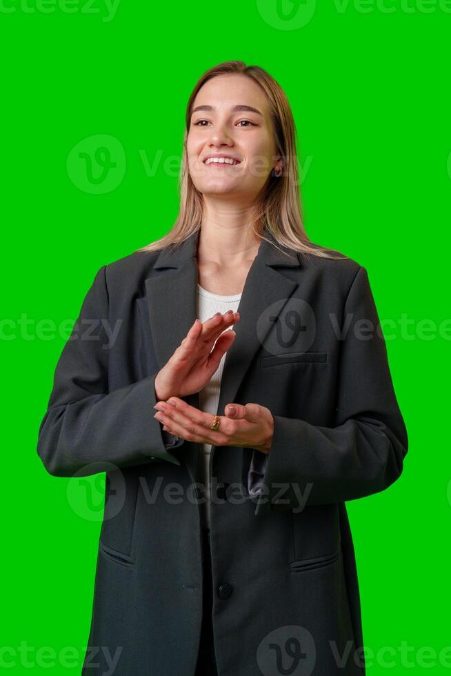 Woman in Black Blazer Clapping on Green Screen Background photo