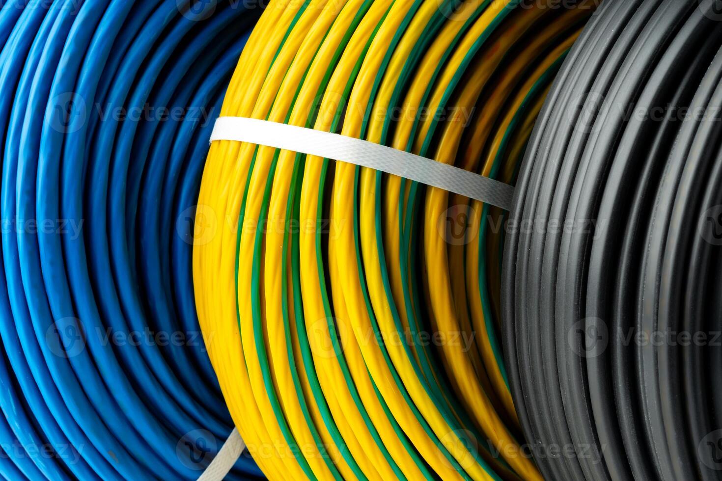 Three Rolls of Electrical Wire in Blue, Yellow and Green, and Black Colors photo