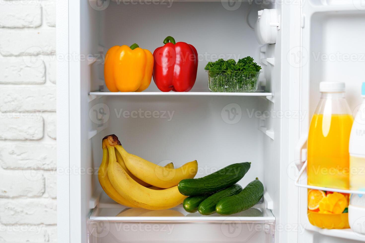 Open Refrigerator With Fresh Produce and Juice photo