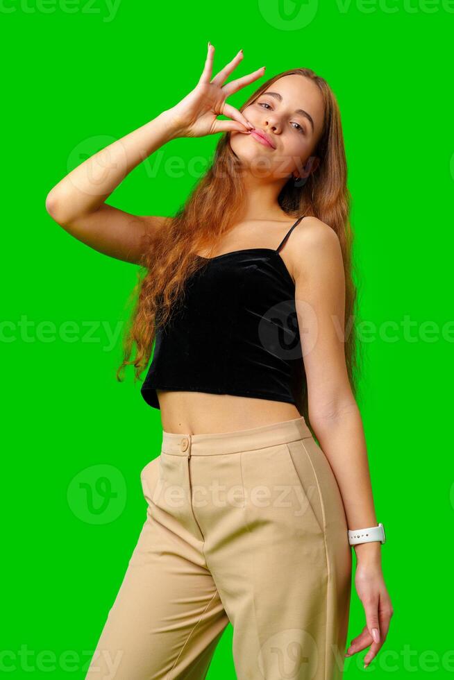 Young Woman Making a Hush Gesture against green background photo
