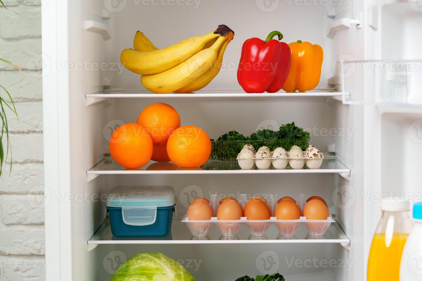 White Refrigerator Open With Fresh Produce and Dairy photo