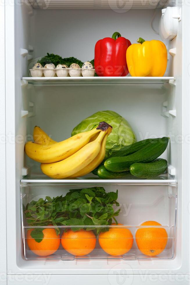 Open Refrigerator Door Showing Fresh Produce Inside photo