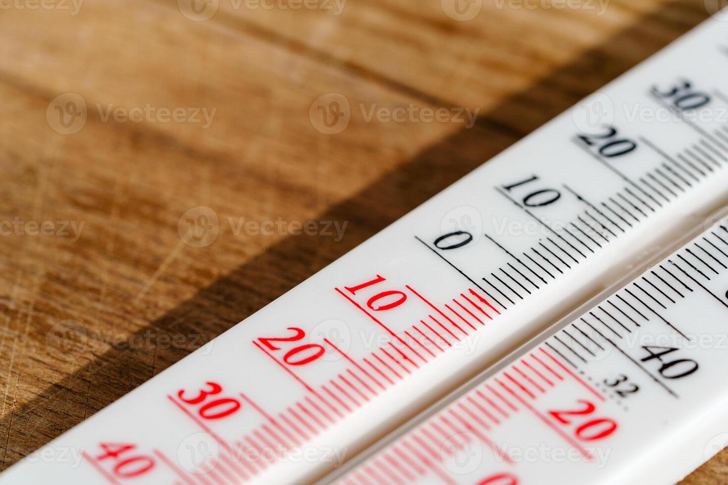 White Thermometer On Wooden Surface Showing A Temperature Of 15 Degrees Celsius photo