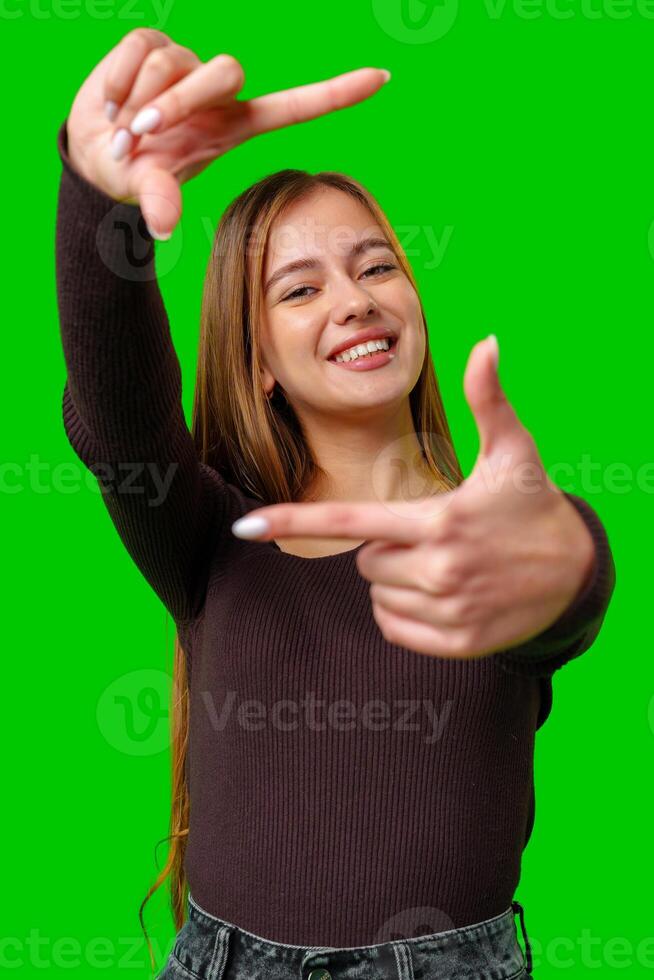 Smiling Woman Making Framing Gesture in Front of Green Screen photo