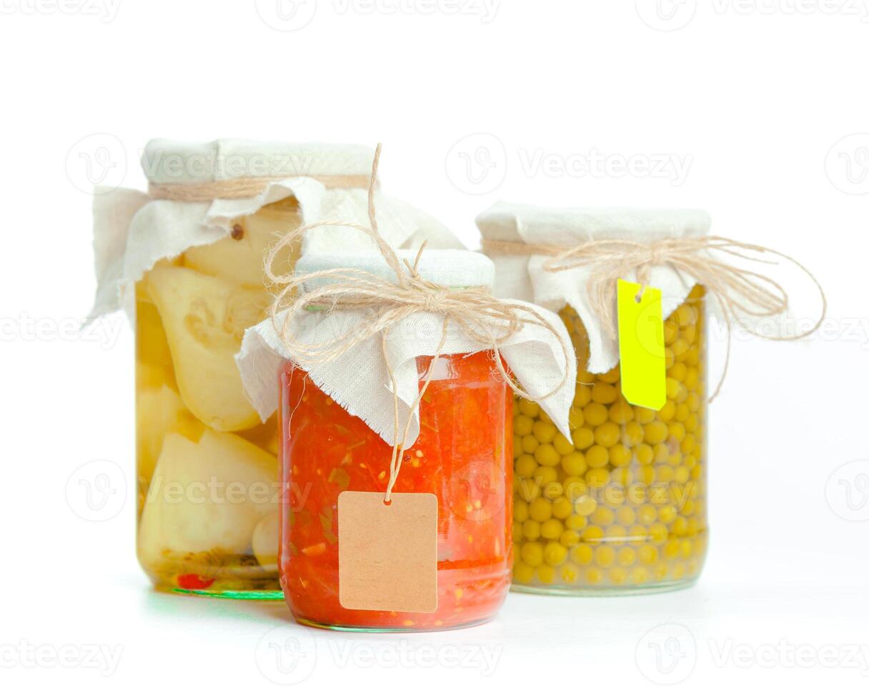 Canned vegetables in glass jars isolated on white background photo