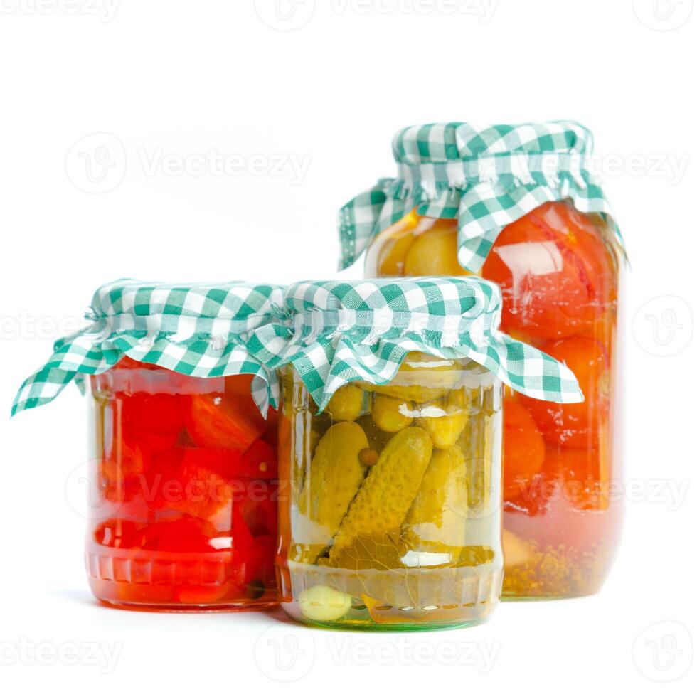 Canned vegetables in glass jars isolated on white background photo