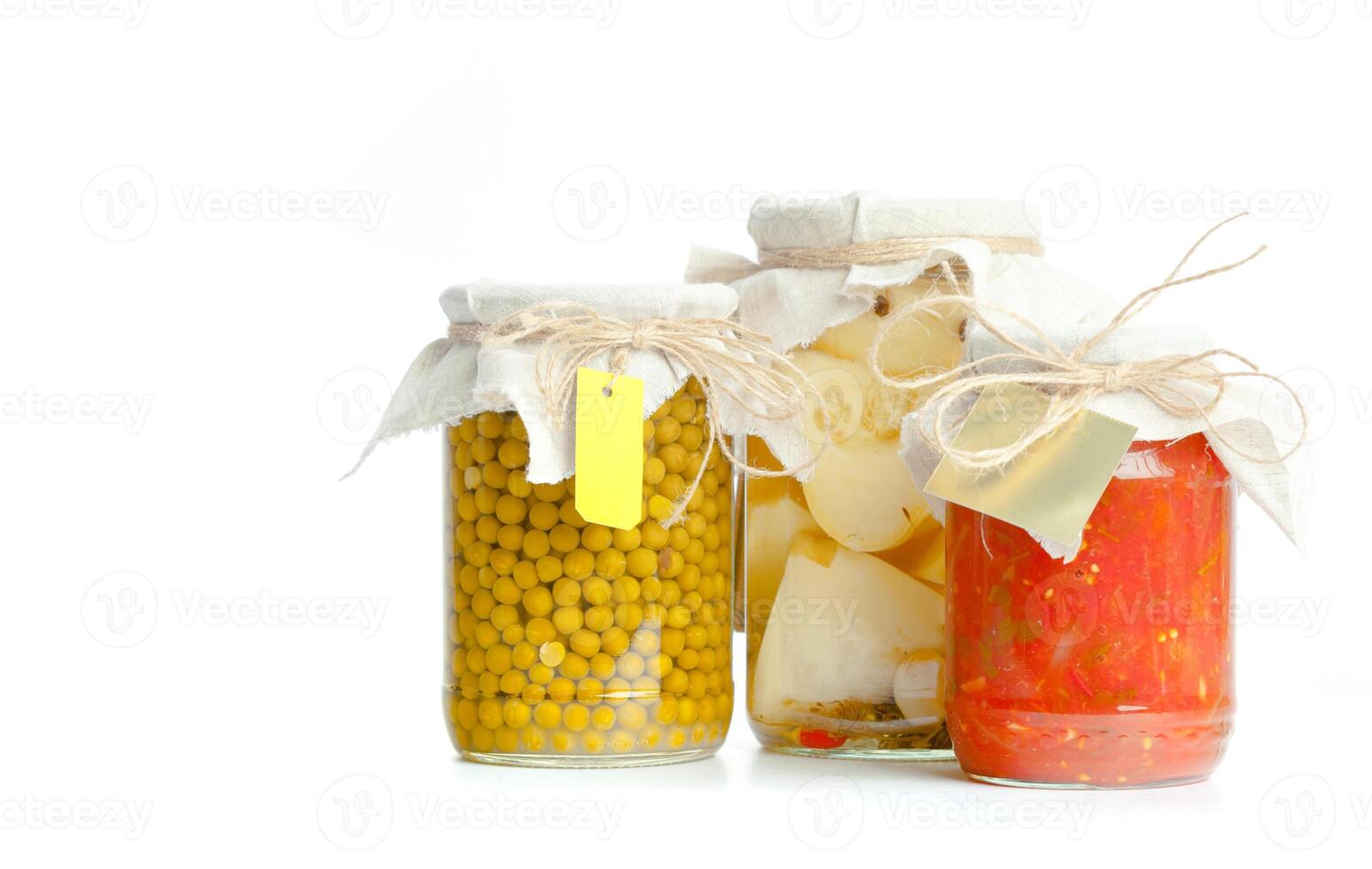 Canned vegetables in glass jars isolated on white background photo