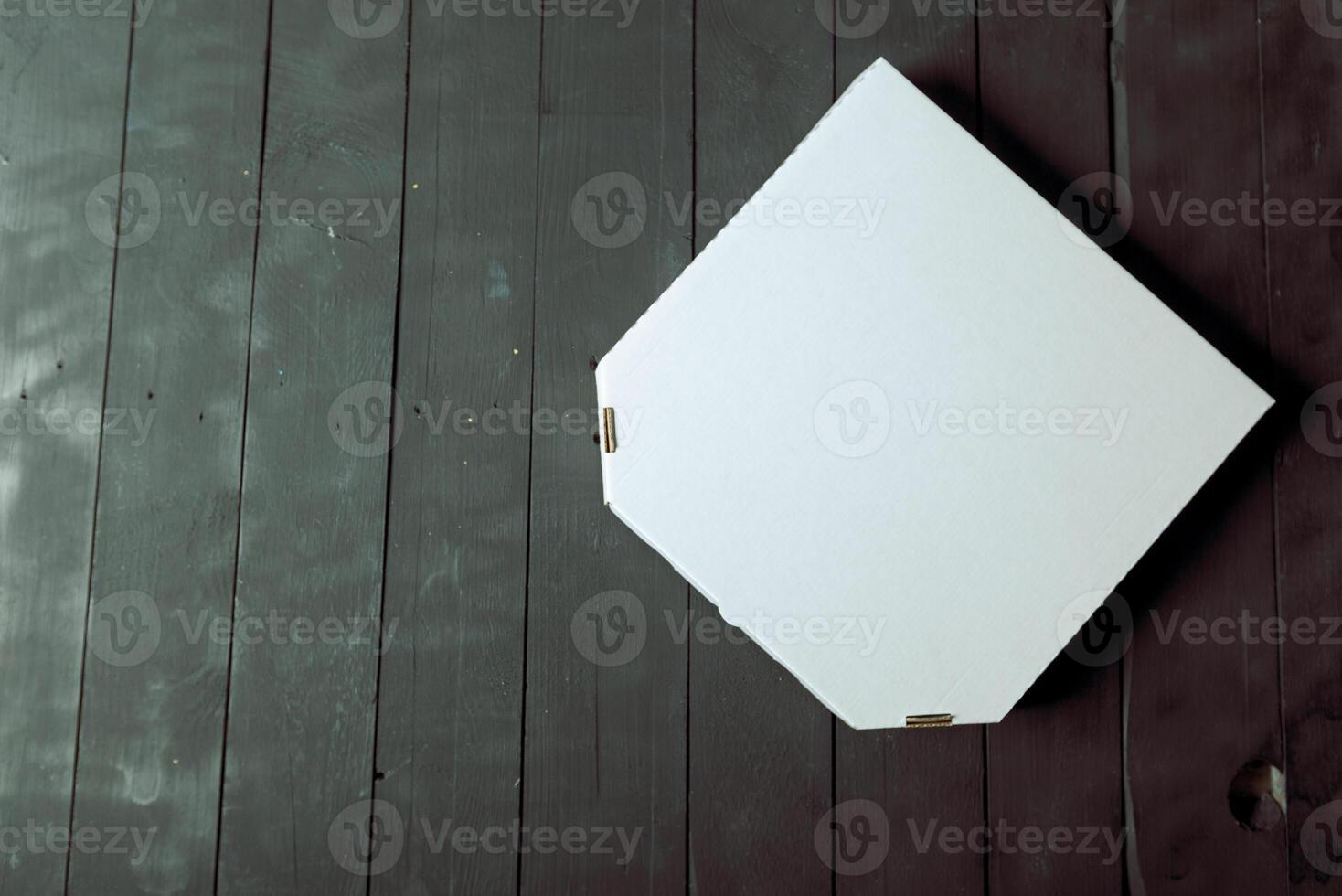 Empty cardboard pizza box on wooden table photo