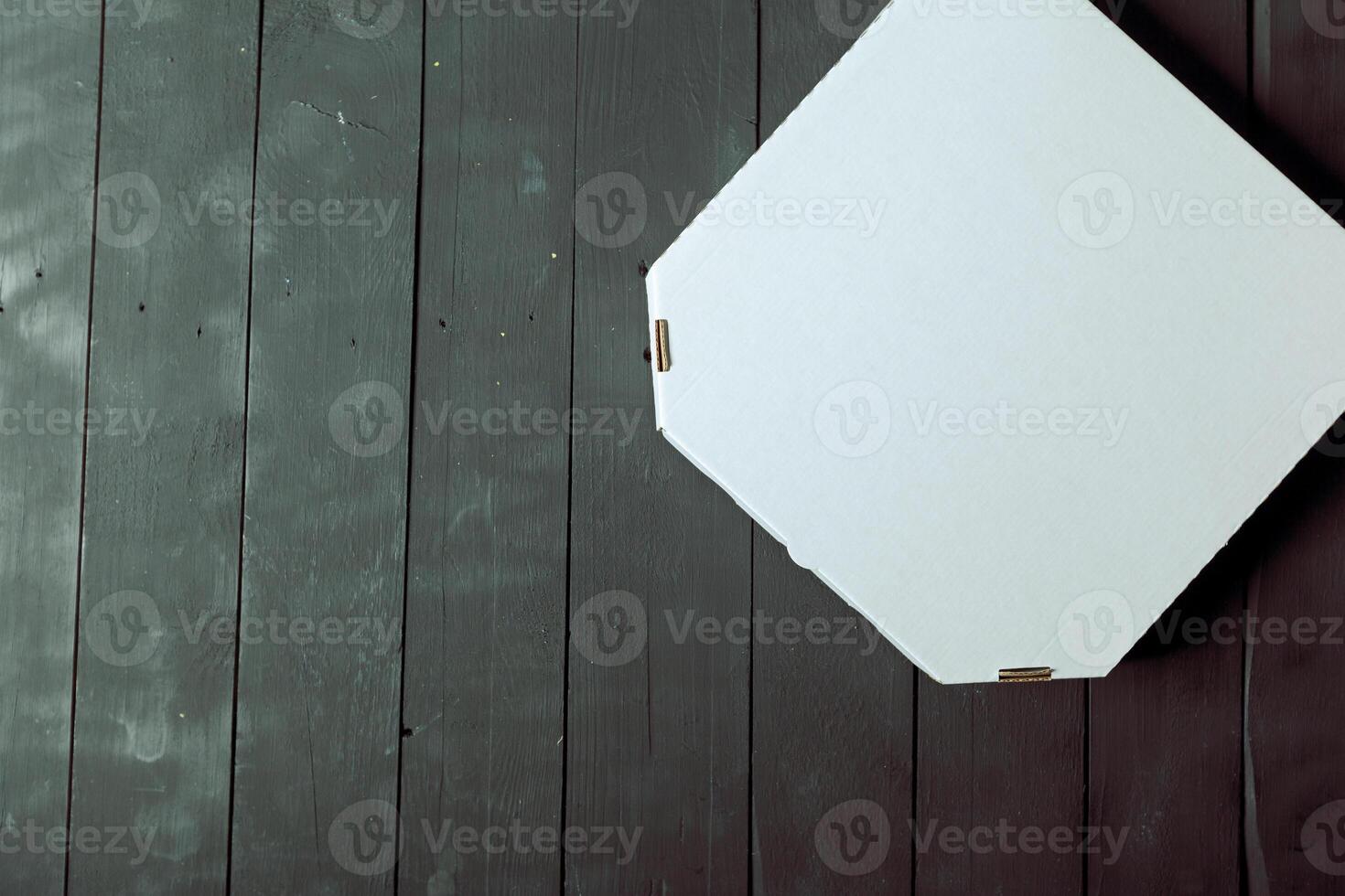 Empty cardboard pizza box on wooden table photo