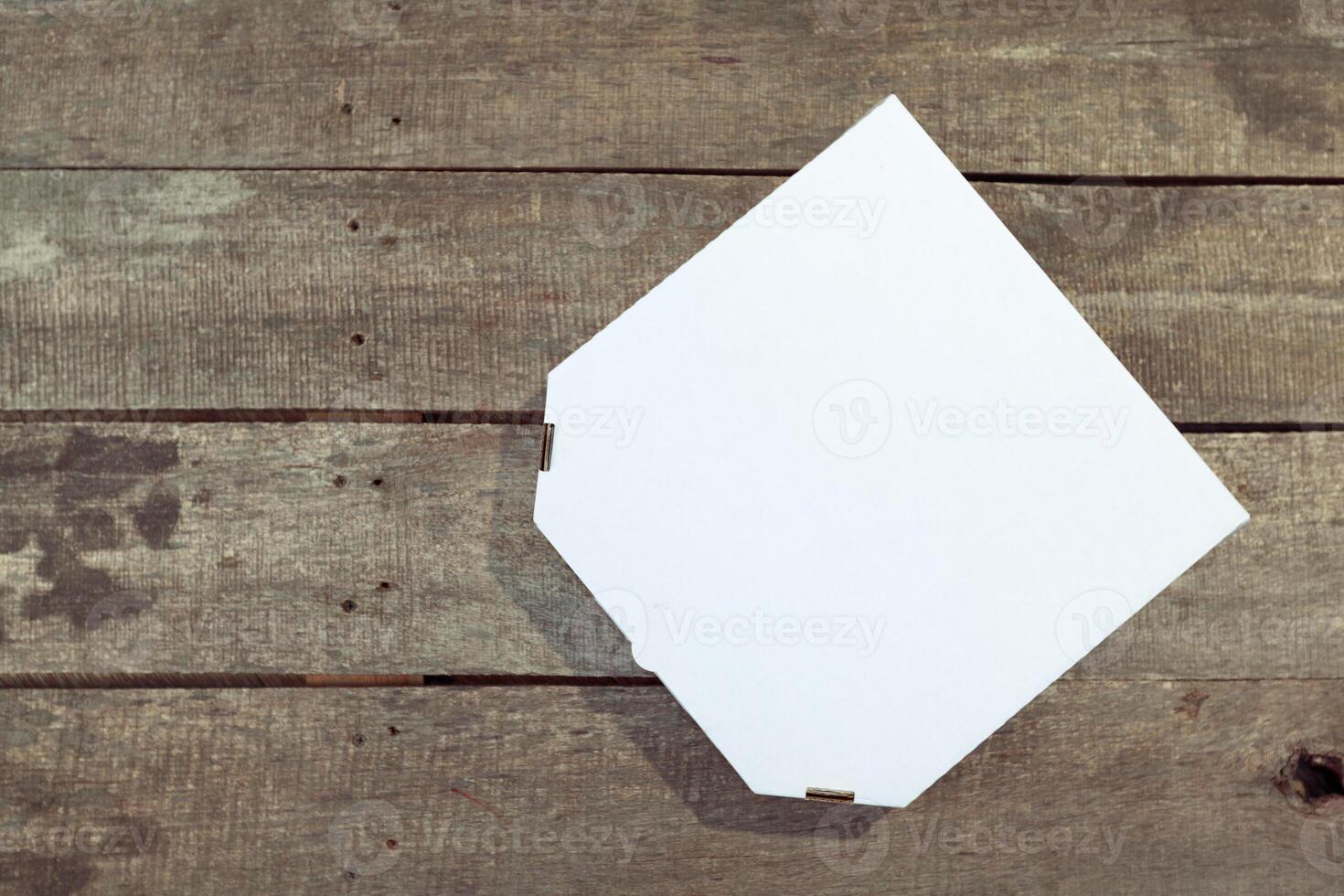 Empty cardboard pizza box on wooden table photo