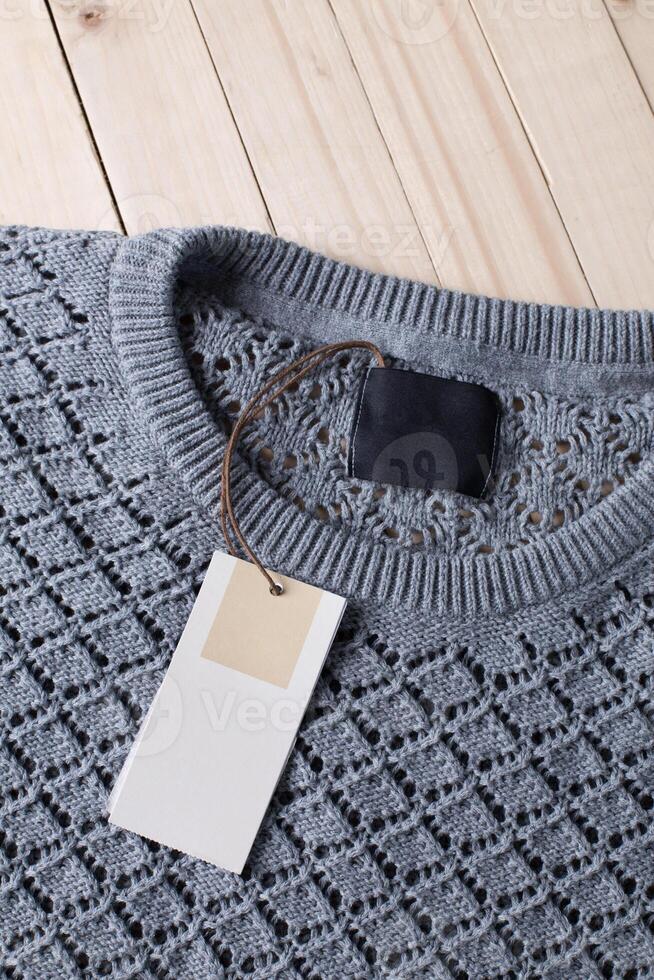 Stack of wool knitted warm sweater and white label for text photo