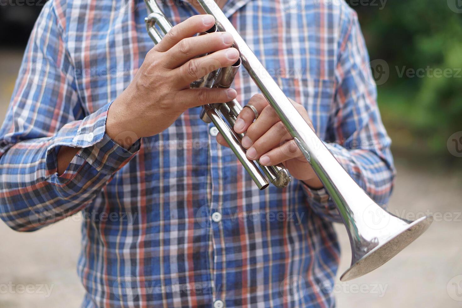 Close up man is holding trumpet. Concept, love music, hobby, recreation activity. Relax time. Lifestyle. Music can develop mental health. Mouthpiece musical instrument. Rehearsal music. photo