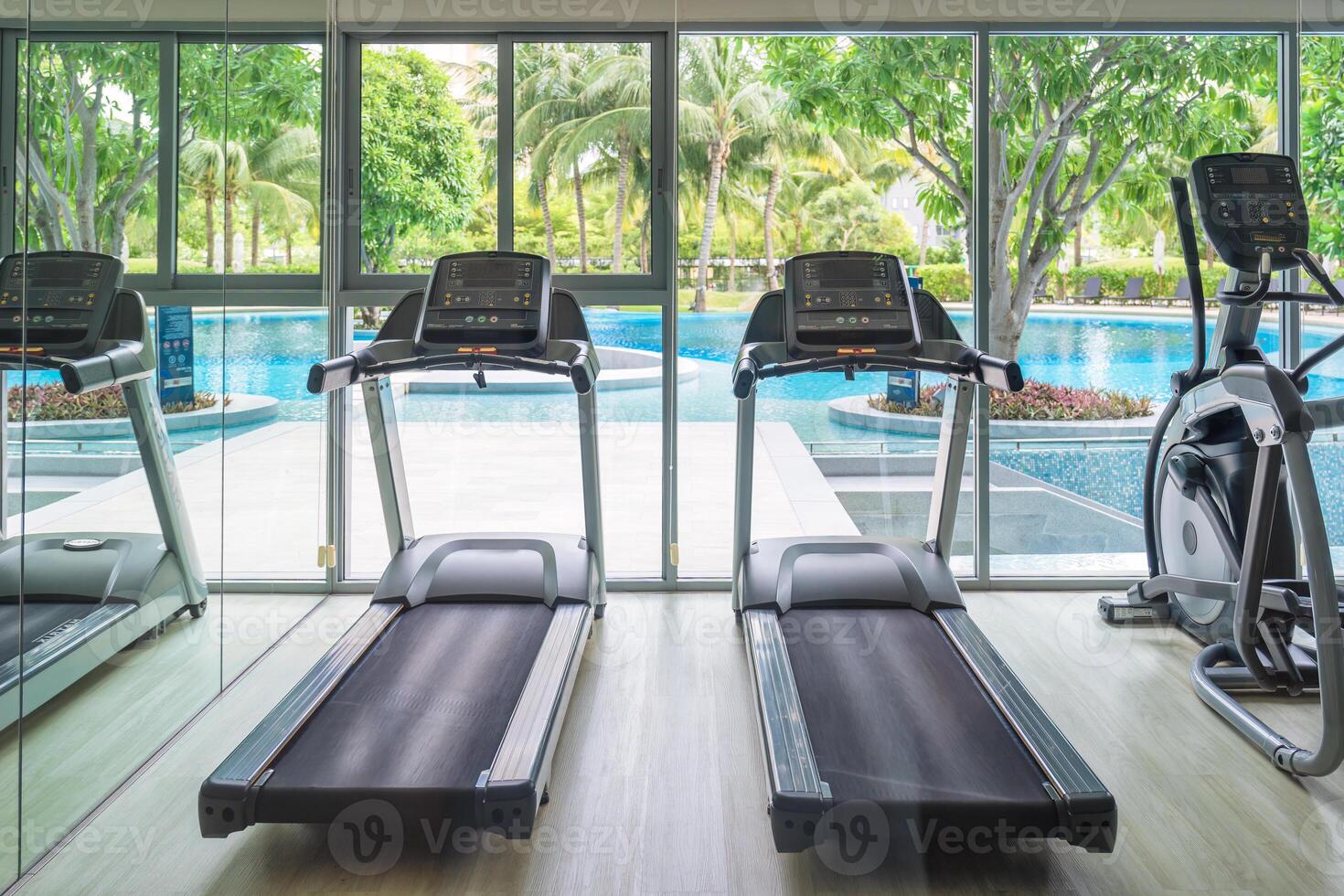 Row of treadmill machine and glass window with garden view in gym photo
