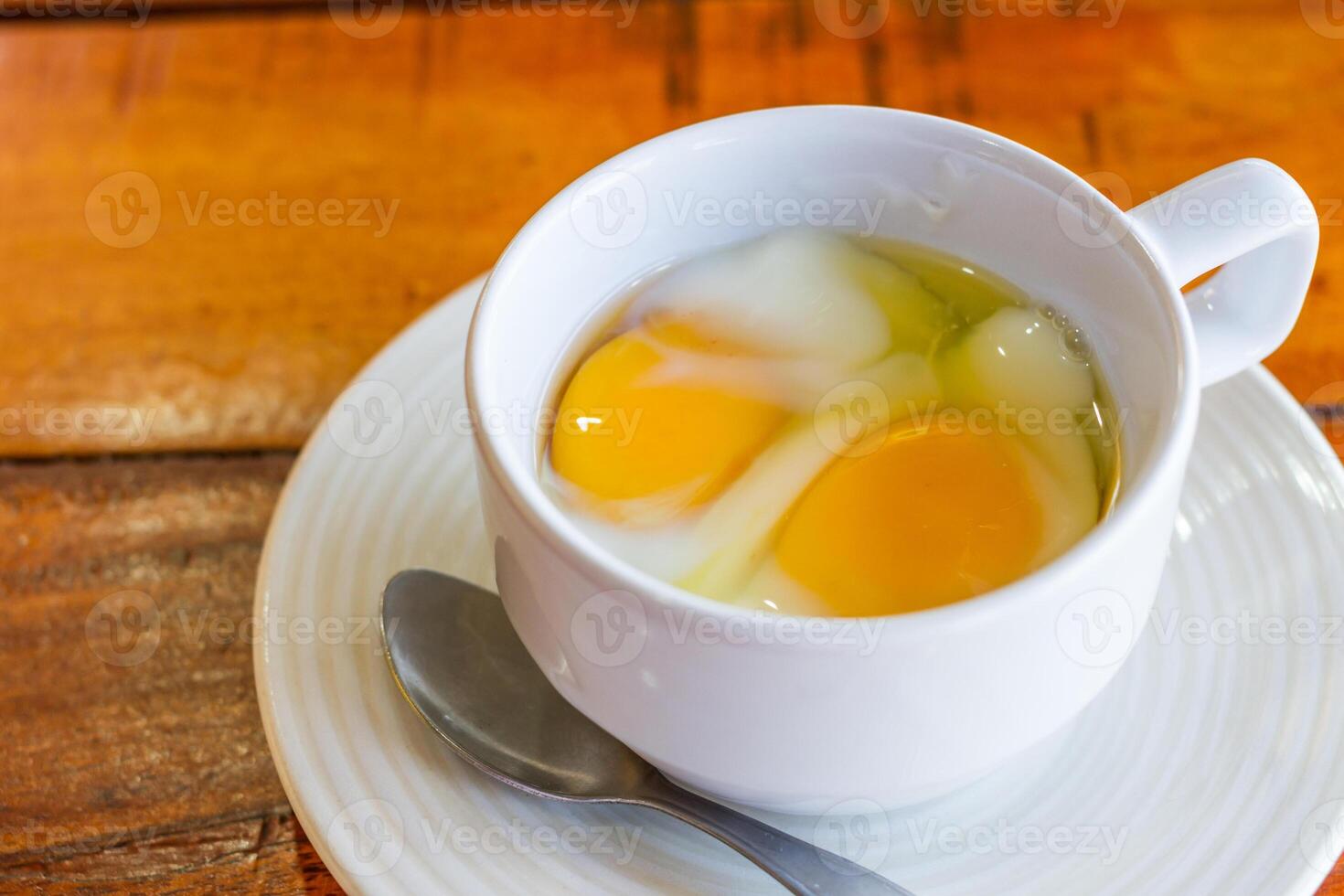 Soft boiled egg in white cup with spoon photo