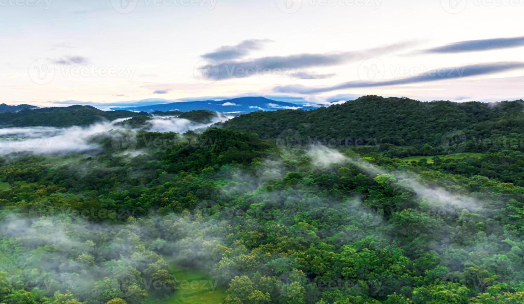 A view of the mountains with clouds and trees photo