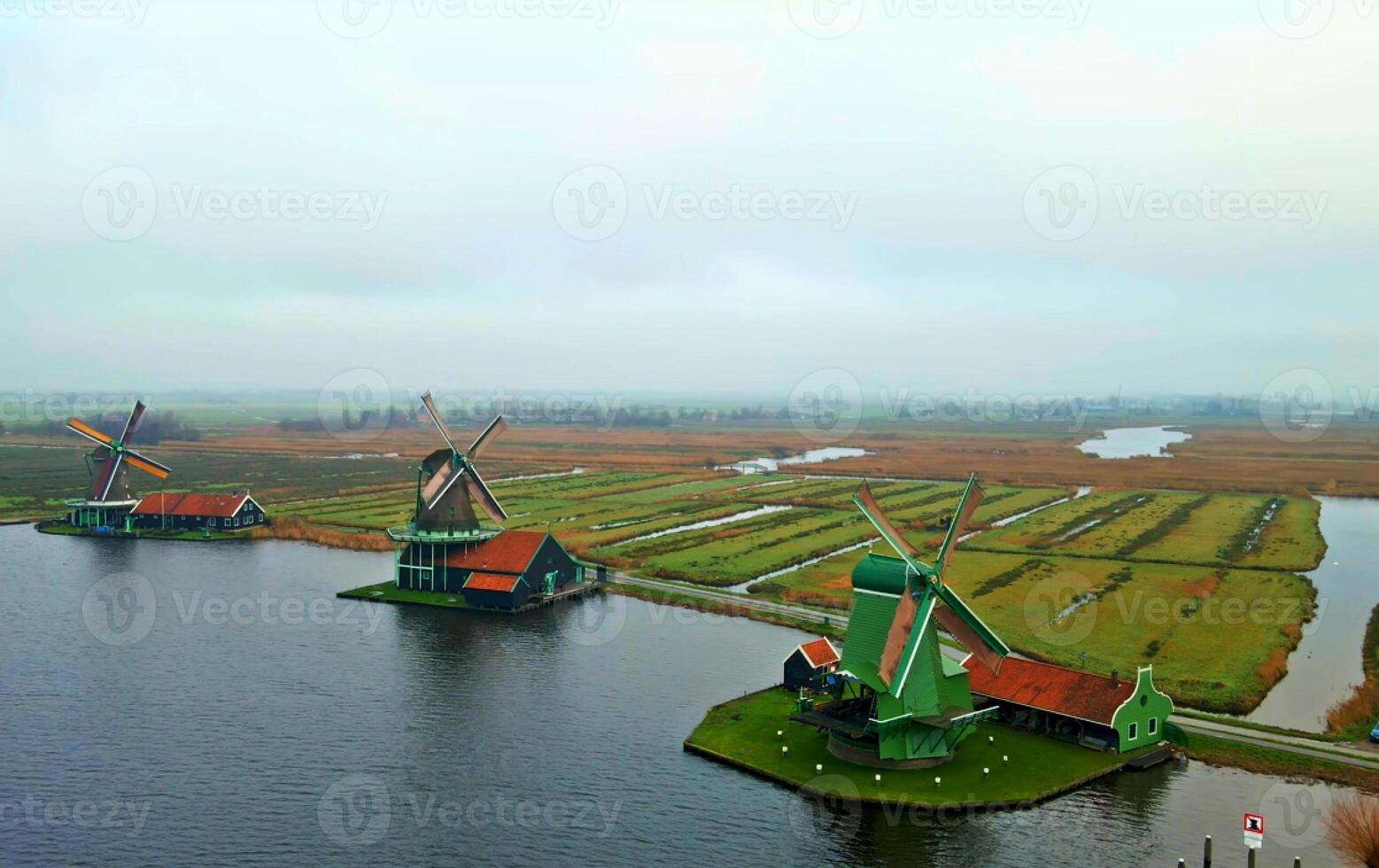Aerial shot of still windmills at River Zaan with the fiends and road towards downtown photo