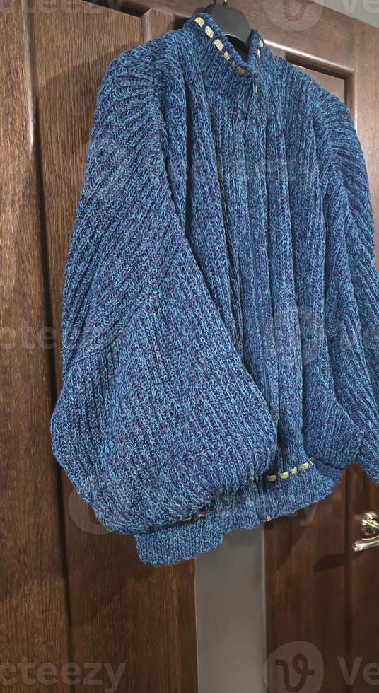Handmade knitted products. Knitted fabric made of dark threads. Woman pullover. photo