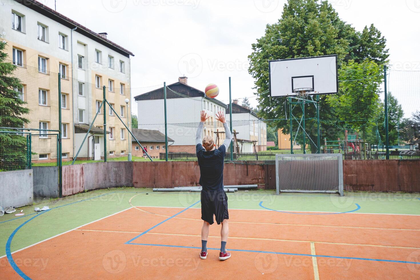 Volleyball player practicing setting the ball on a hard court, focusing on control and precision during an outdoor training session. A calm, focused moment in the game photo