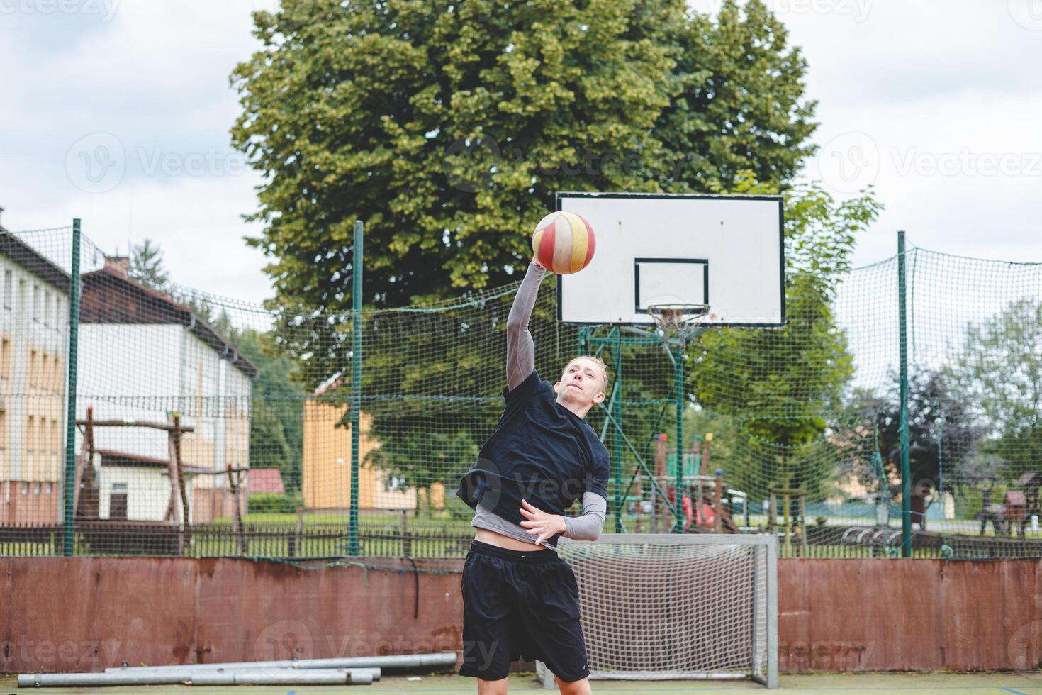 Volleyball player is serving on a hard court during an outdoor game. The action showcases athleticism, agility, and control in a dynamic volleyball setting photo