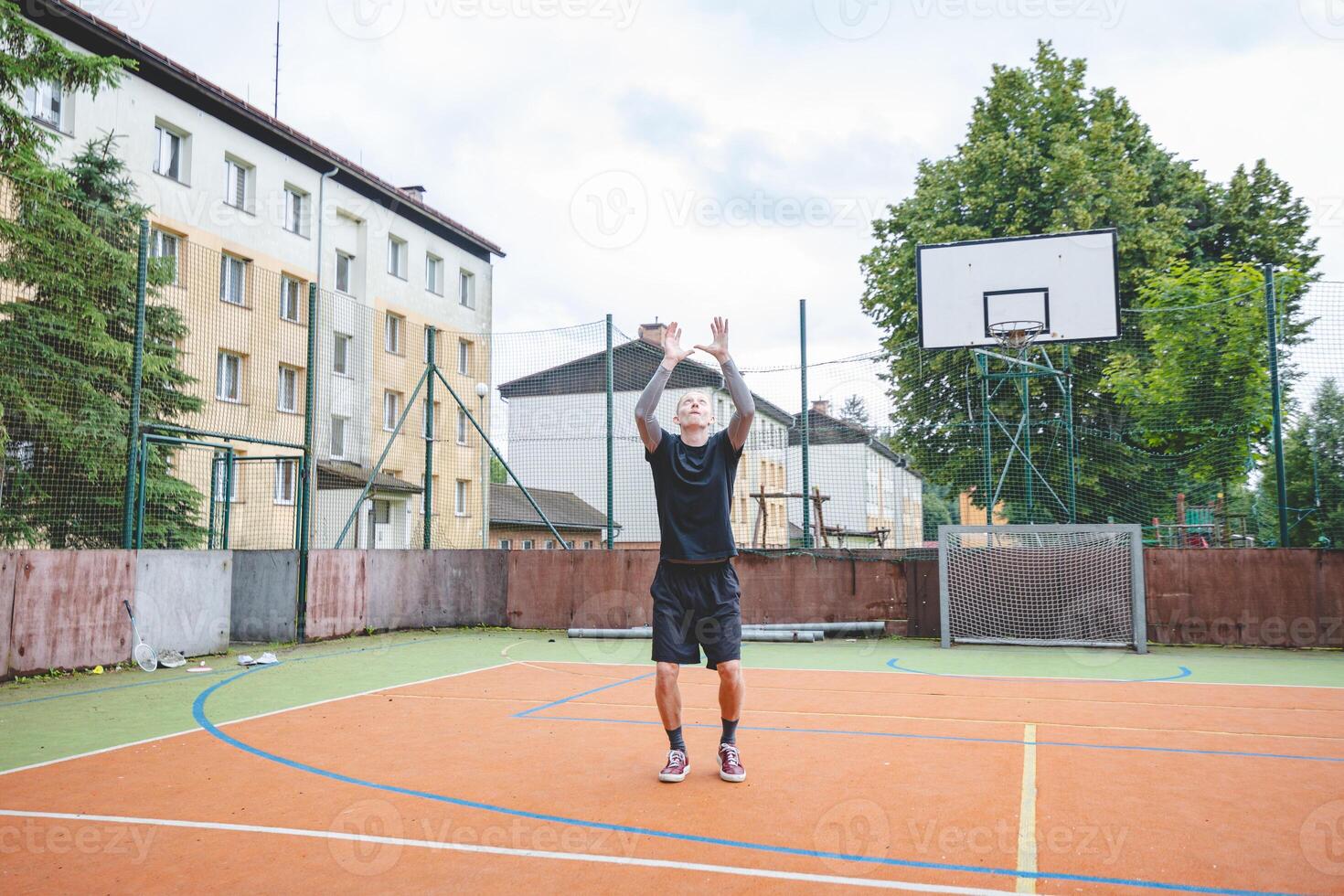 Volleyball player practicing setting the ball on a hard court, focusing on control and precision during an outdoor training session. A calm, focused moment in the game photo
