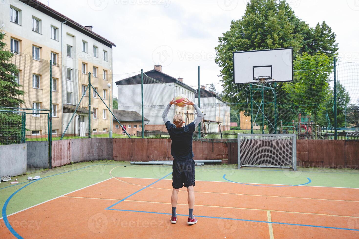 Volleyball player practicing setting the ball on a hard court, focusing on control and precision during an outdoor training session. A calm, focused moment in the game photo