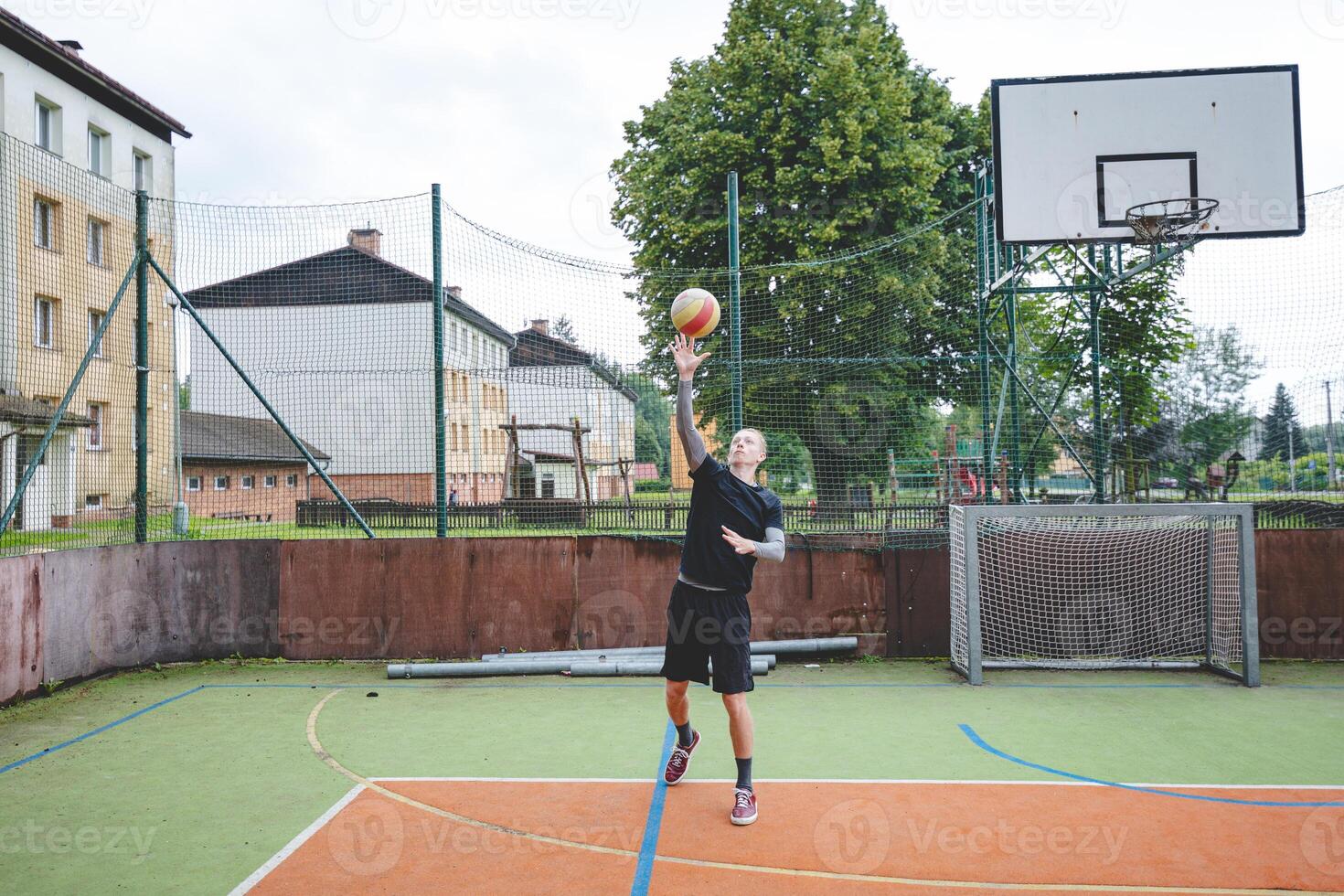 Volleyball player is serving on a hard court during an outdoor game. The action showcases athleticism, agility, and control in a dynamic volleyball setting photo