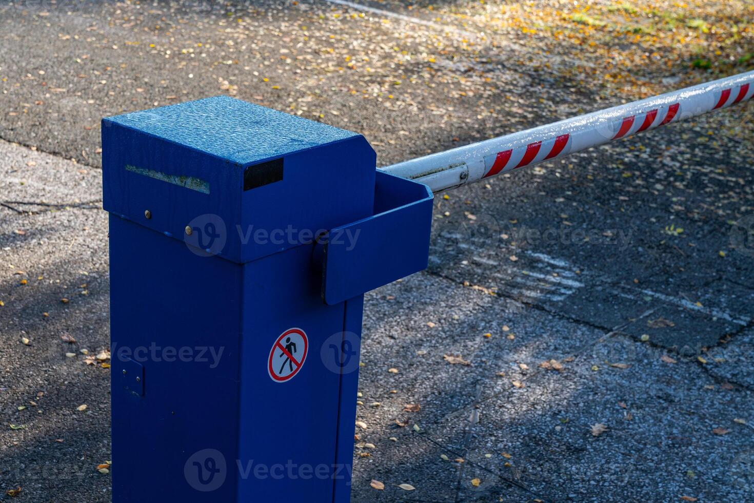A blue entrance barrier stands at the entrance of a parking lot photo