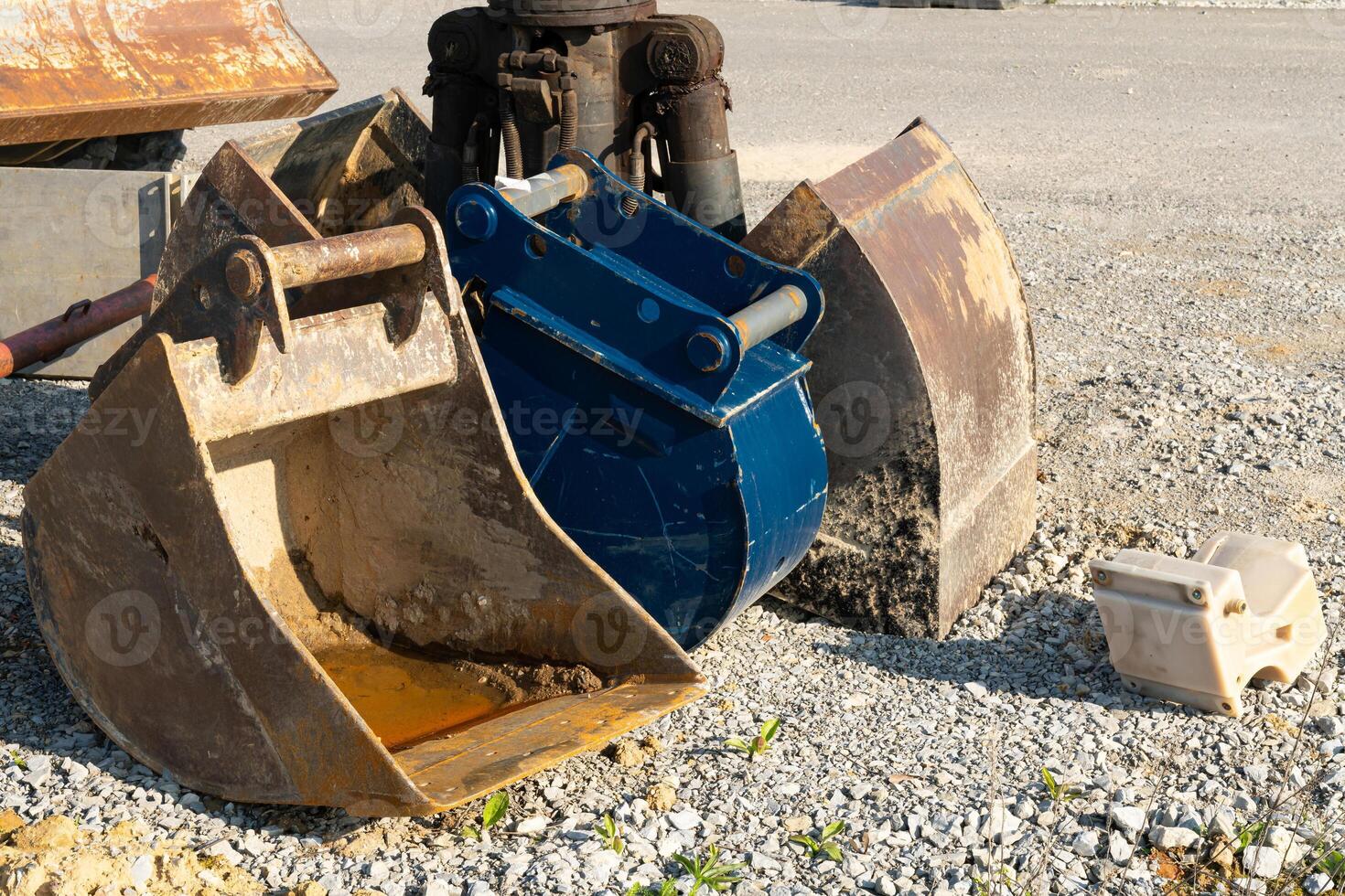 Dirty excavator buckets standing on a construction site. photo