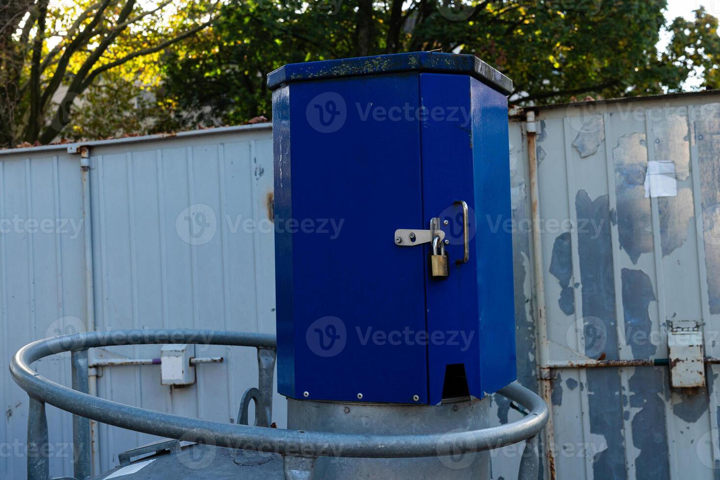 A blue control box secured with a lock is positioned on top of a photo