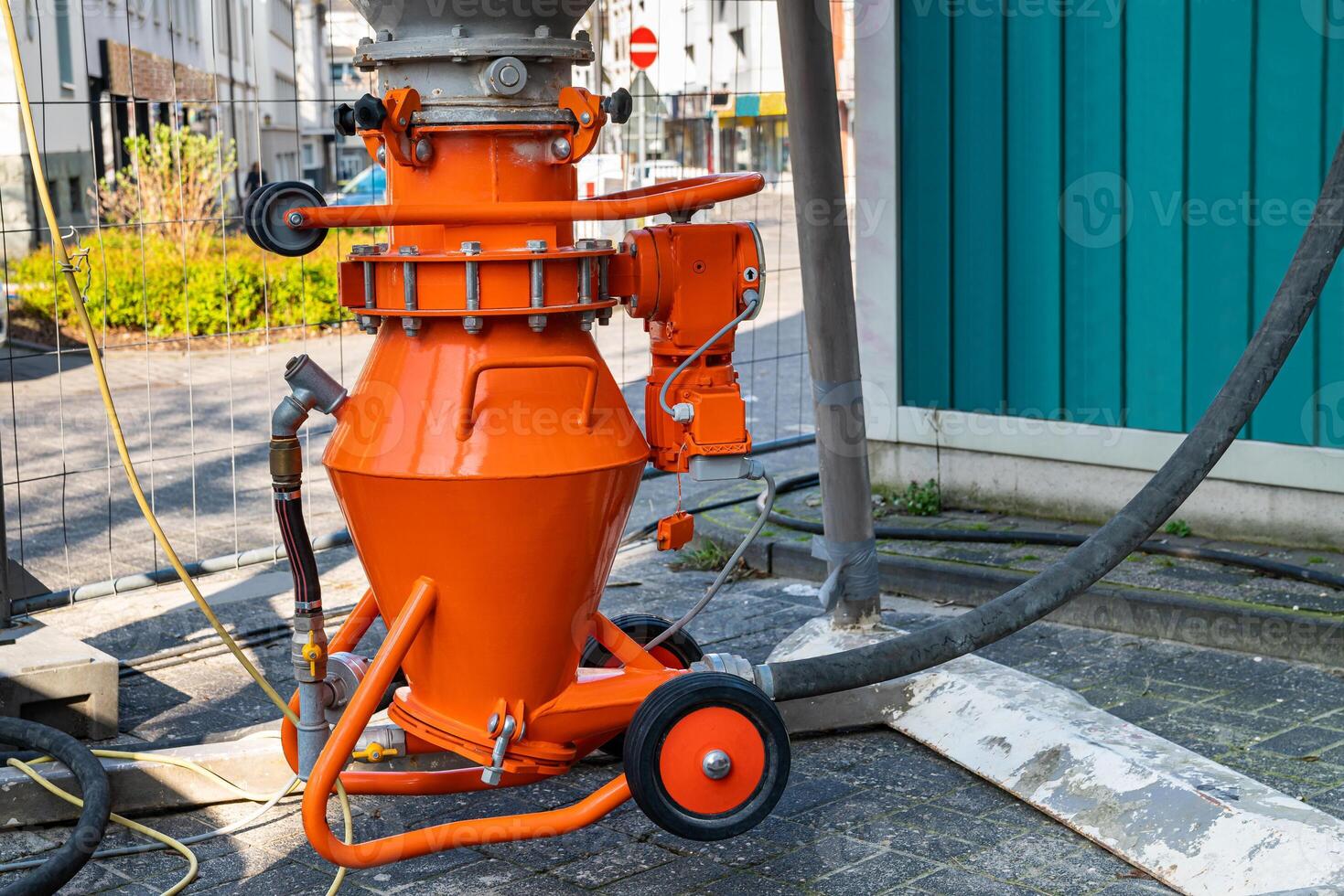 Orange mortar mixer with motor and supply hoses. Close up. photo