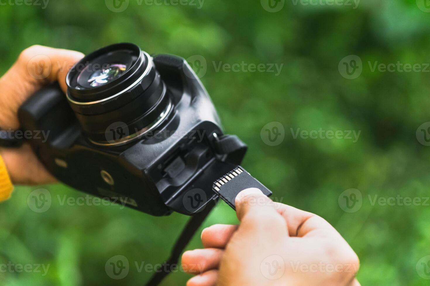 Hands of a Photographer inserting the memory card into the camera. technology and backup concept. photo