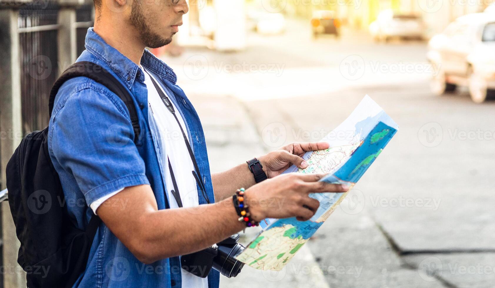 man from behind looking at a map looking for a location. travel and tourism concept. photo