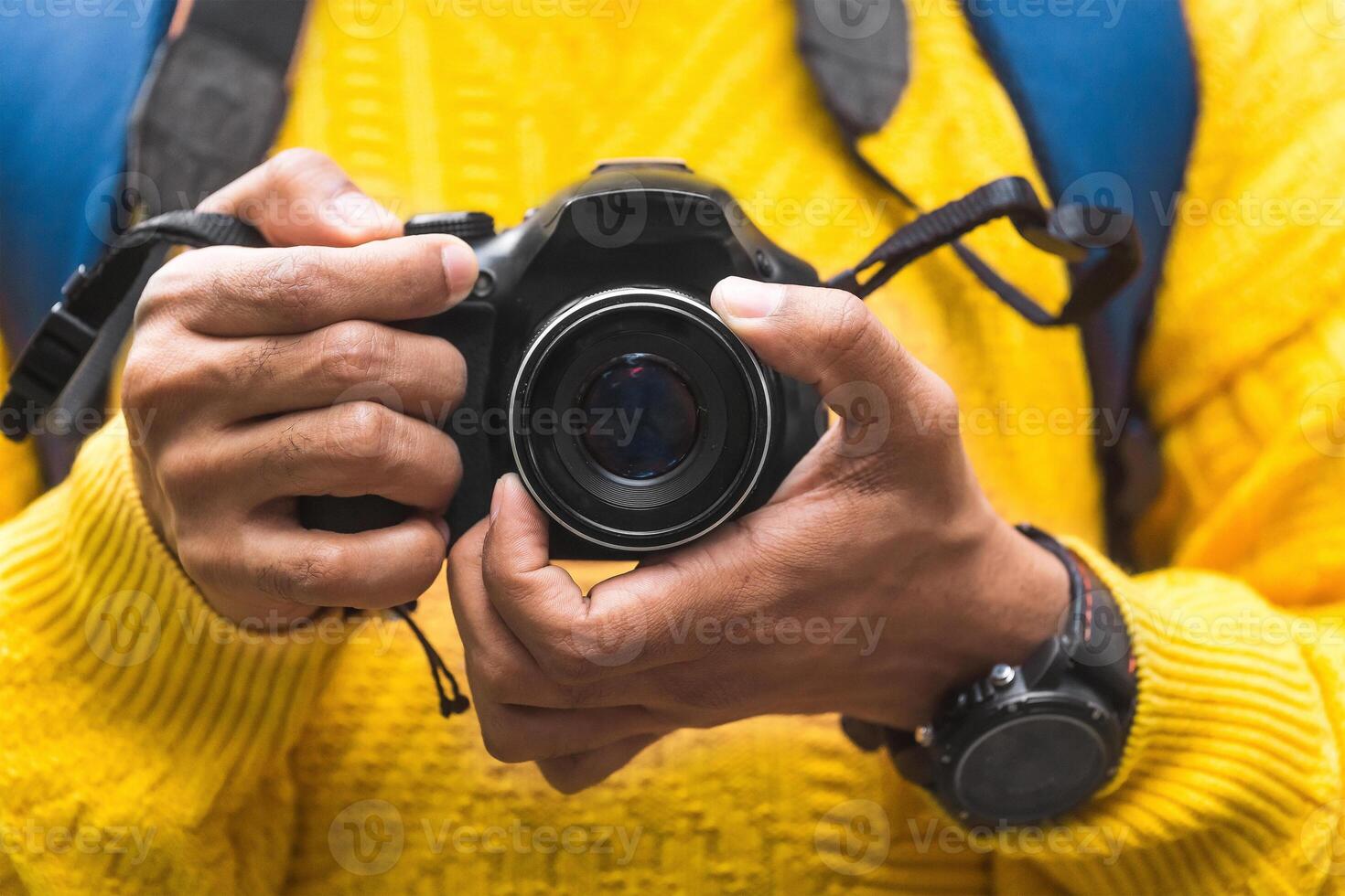 A hands of an unrecognizable person or photographer holding a professional camera. travel and backpacker concept. photo