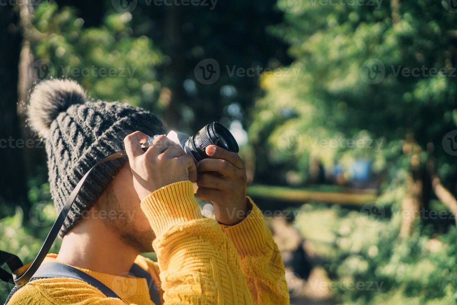 young traveler holding an analog camera taking a photo. nature travel concept. photo