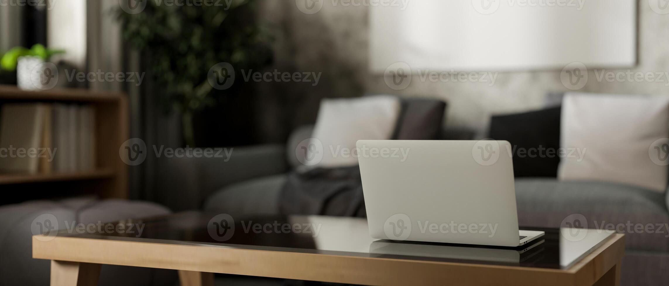 A back view of a laptop on a coffee table in a contemporary, loft living room. photo