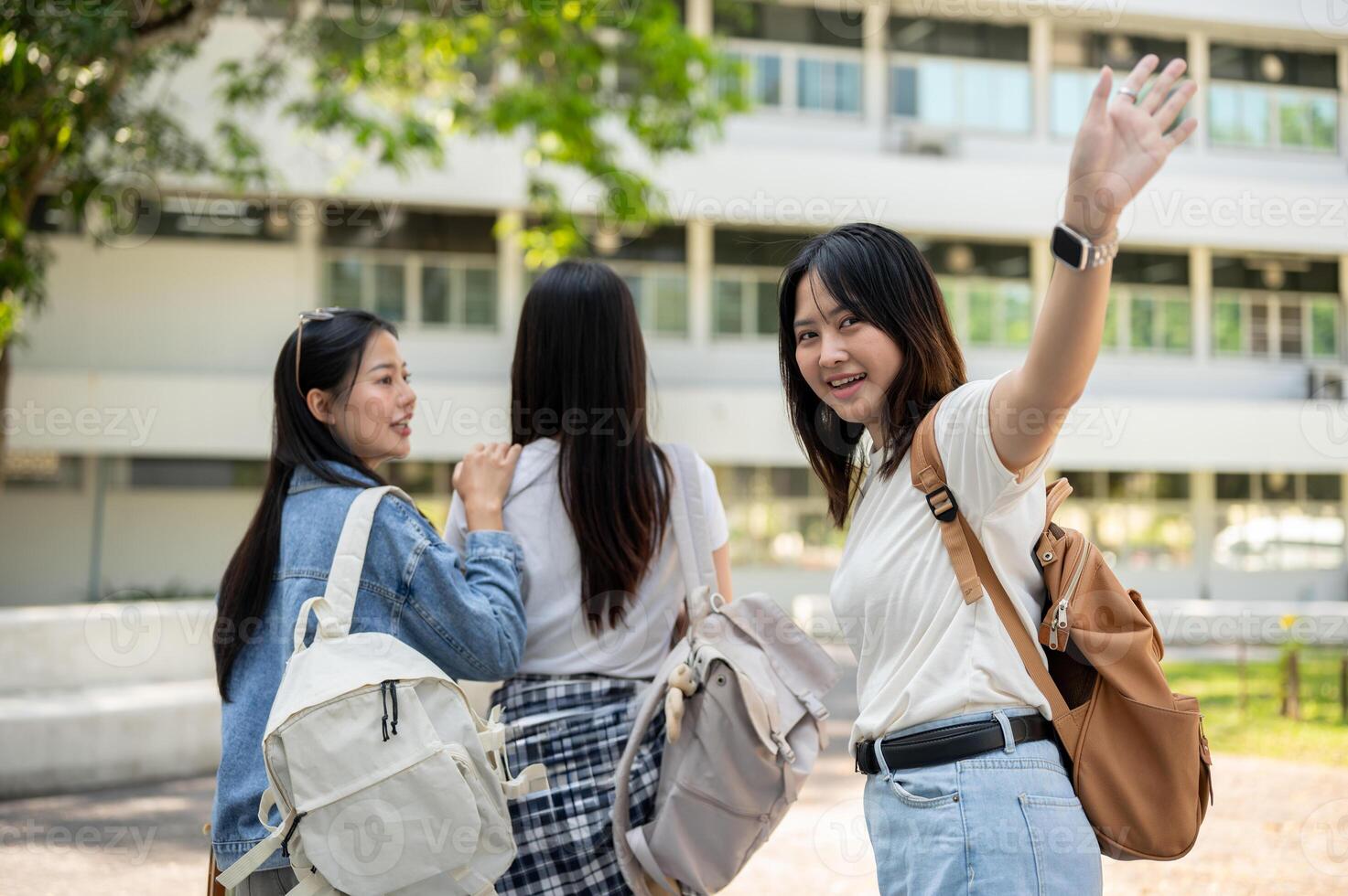 A happy Asian female college student is on the way to class with her friends. photo