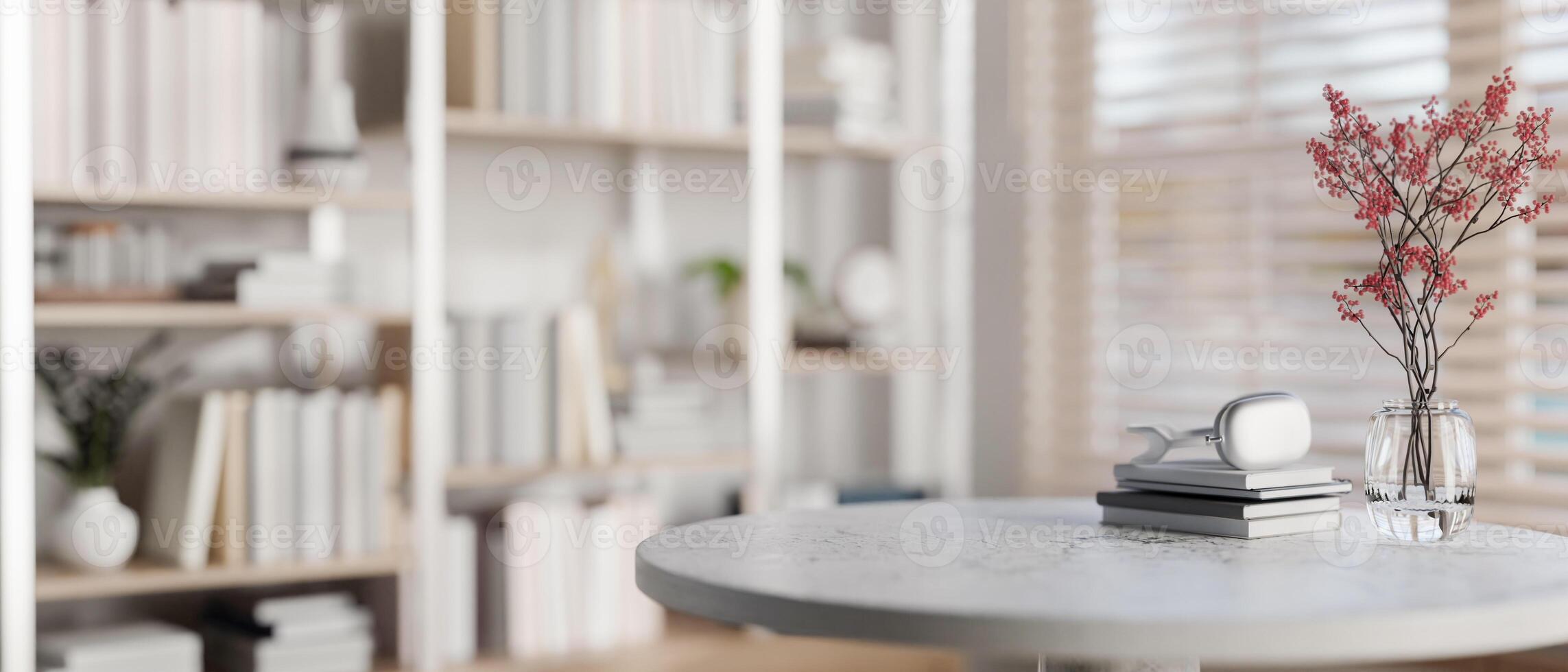 A space for displaying products on a round table with a large bookshelf in the background. photo