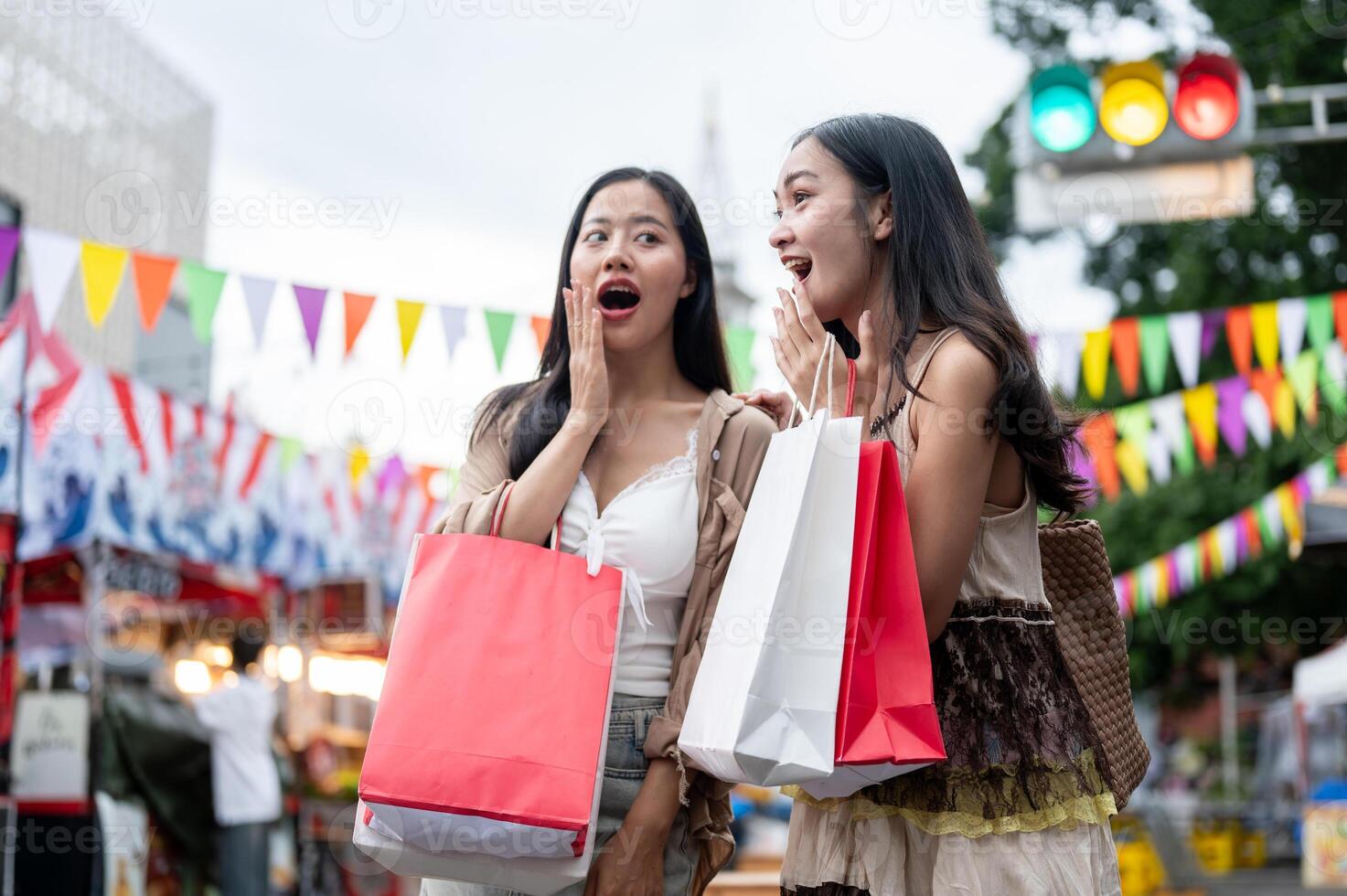 Cheerful Asian female friends are excited and amazed by the various food stalls at a night market. photo