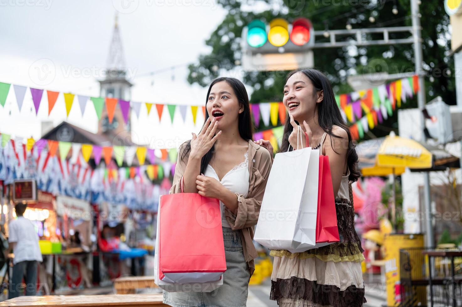 Cheerful Asian female friends are excited and amazed by the various food stalls at a night market. photo