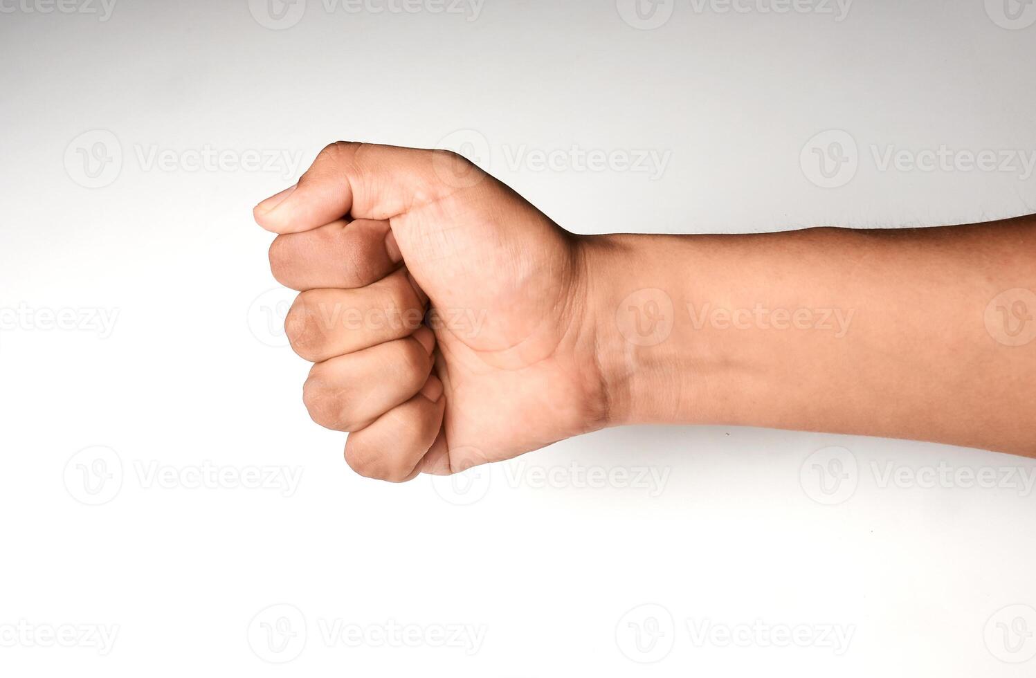 Close-up of closed hand, fist, rock gesture with white background. Hand of latin man. photo